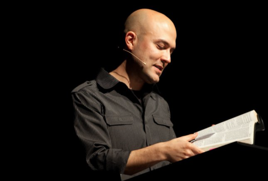 A young Joshua Harris reading from the Bible against a black backdrop