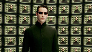Keanu Reeves in front of wall of screens with his face: deepfake apologist?