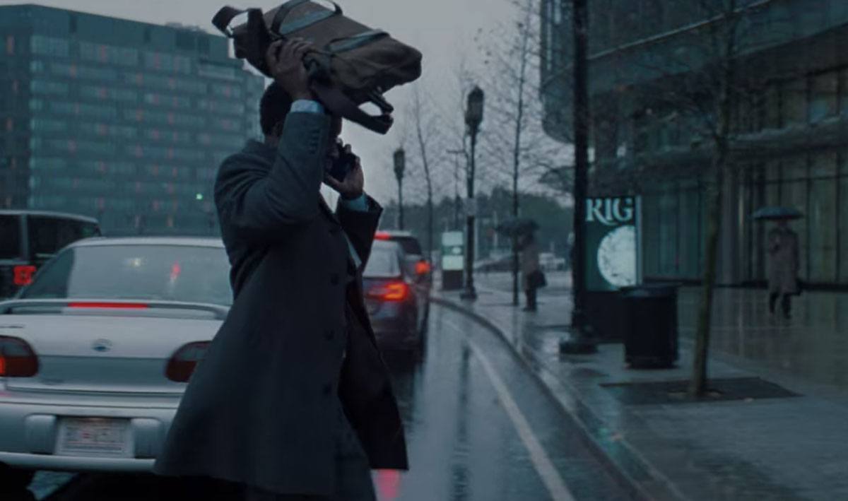 Dr. Teddy Oglethorpe heads into NASA in front of a "RIG" ad in Don't Look Up