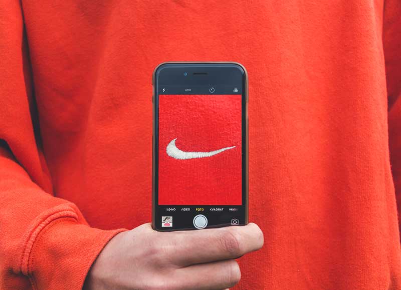 A person snaps a photo of their sweatshirt with a Nike logo in the age of the personal brand and the creator economy - photo by Kristian Egelund