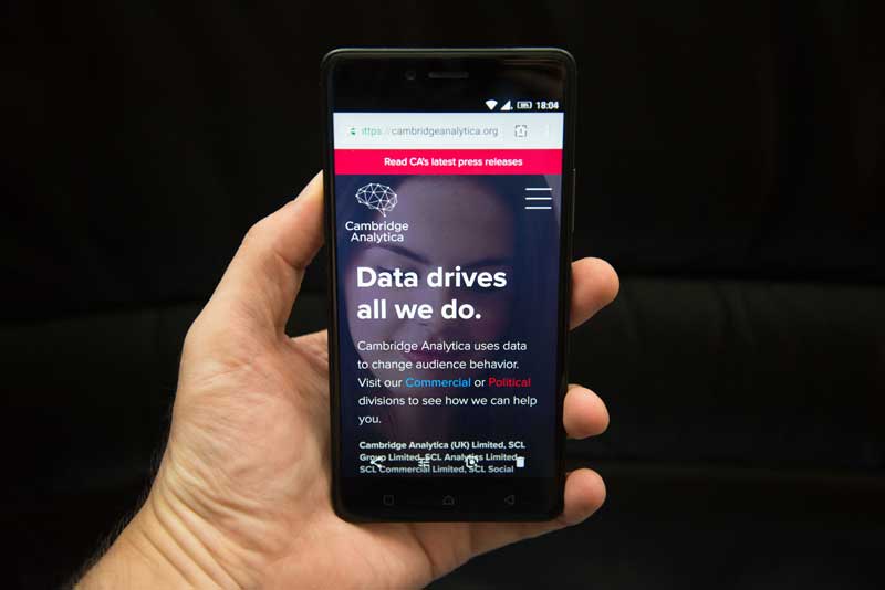 Hand holding Cambridge Analytica phone with copy "Data drives all we do"